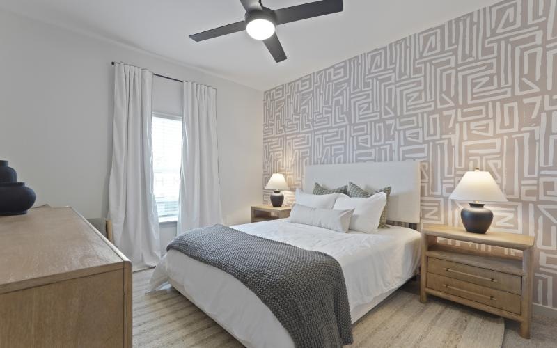 a bedroom with a bed and a fan